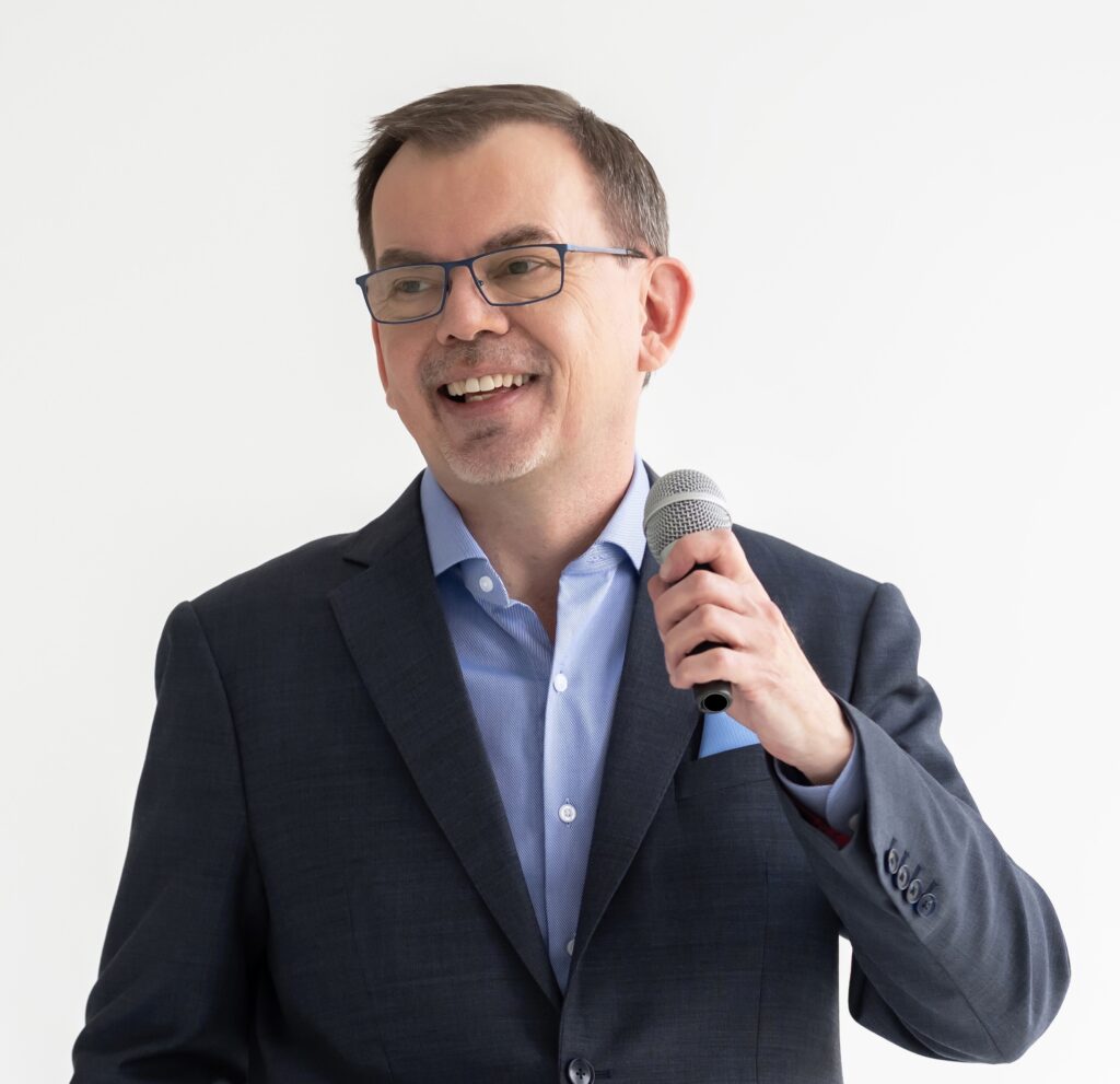 Head, shoulders and chest shot of Jason Reid with microphone